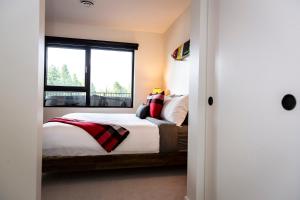 1 dormitorio con 1 cama y ventana en The Shred Shack - Stylish Revelstoke Condo, en Revelstoke
