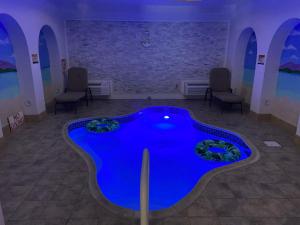 a pool in a room with chairs and a brick wall at Inn of the Dove Cherry Hill - Philadelphia in Cherry Hill