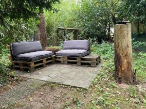 2 sedie sedute su un patio accanto a un albero di Gezellige Caban in de natuur a Lanaken