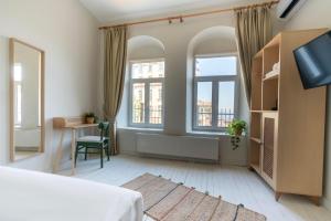 een slaapkamer met een bed, een bureau en 2 ramen bij Atlas Han Hotel in Istanbul