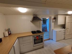 cocina con armarios blancos y fogones en Sørlandshus med 3 soverom en Arendal