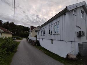 un edificio bianco sul lato di una strada di Sørlandshus med 3 soverom ad Arendal Altre 26 foto