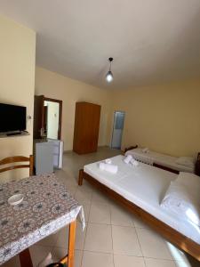 萨兰达Kevi Guesthouse的有两张床和一张桌子的酒店房间