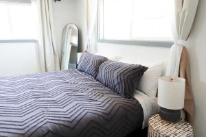 a bed in a bedroom with a window and a lamp at Northbank Loft in Springfield