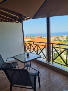 einen Tisch und Stühle auf einem Balkon mit Aussicht in der Unterkunft Este Luxury Apartments in Kriopigi