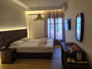 una camera con letto, scrivania e finestra di Este Luxury Apartments a Kriopigi