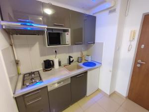 a kitchen with a sink and a microwave at Top Apartamenty Centrum - Rondo ONZ in Warsaw