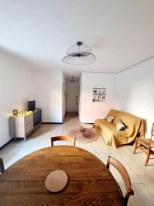 sala de estar con mesa y sofá en Appartement avec jardin proche de la mer, en Valras-Plage