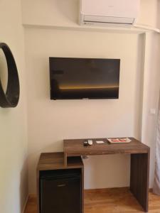Zimmer mit einem Tisch und einem TV an der Wand in der Unterkunft Este Luxury Apartments in Kriopigi