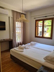 1 dormitorio con 1 cama grande y toallas. en Este Luxury Apartments, en Kriopigi