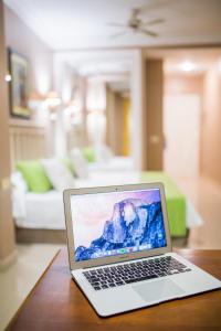 Hotel RF Astoria - Adults Only في بويرتو دي لا كروث: يوجد جهاز كمبيوتر محمول على طاولة في غرفة المعيشة
