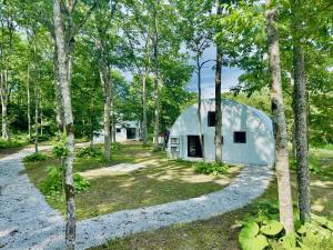 een witte schuur in het bos met bomen bij FOX&CRANE Cabin - Vacation STAY 97723v in Teshikaga