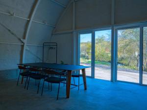 a table and chairs in a room with windows at FOX&CRANE Cabin - Vacation STAY 97723v in Teshikaga