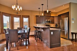 a kitchen with a table with chairs and a refrigerator at Rabaska by Rendez-Vous Mont-Tremblant in Mont-Tremblant