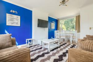 sala de estar con paredes azules, mesa y sillas en Comfy Home Moseley en Birmingham