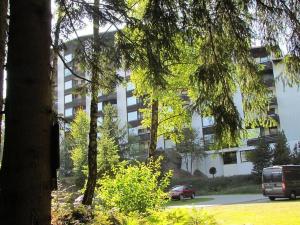 a large white building with cars parked in front of it at Apartement Wald-Panorama Fuchsenstein in Spiegelau