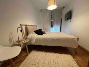 a bedroom with a bed and a table and a chair at Origen Santoña, apartamento céntrico hasta 4 plazas y fácil aparcar, opcional garaje in Santoña