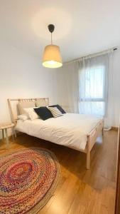 una camera con letto, tappeto e finestra di Origen Santoña, apartamento céntrico hasta 4 plazas y fácil aparcar, opcional garaje a Santoña