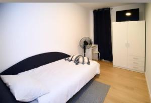a bedroom with a white bed with a black headboard at Kuća za odmor Deda Pepo in Mičevec +8 photos
