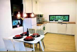 uma cozinha com uma mesa branca e um frigorífico branco em Kuća za odmor Deda Pepo em Mičevec
