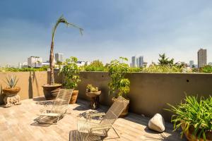 a patio with chairs and potted plants on a roof at Chic PH Haven with rooftop, Condesa 2BR By Tasman in Mexico City