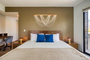 a bedroom with a large bed with blue pillows at Chic PH Haven with rooftop, Condesa 2BR By Tasman in Mexico City