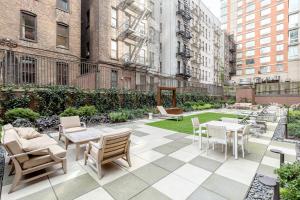 a patio with tables and chairs in a city at Midtown W 1BR w Gym Doorman nr Times Sq NYC-692 in New York