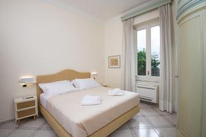 - une chambre avec un lit doté de draps blancs et une fenêtre dans l'établissement B&B Marcantonio - Ischia Ponte, à Ischia