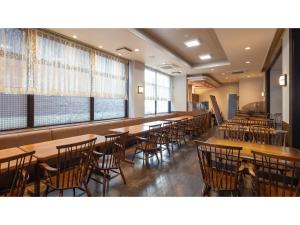 Matto Terminal Hotel - Vacation STAY 98879v في Hakusan: غرفة طعام مع طاولات وكراسي ونوافذ