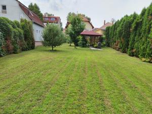een tuin met een groot gazon en een huis bij Villa Viktoria in Hévíz