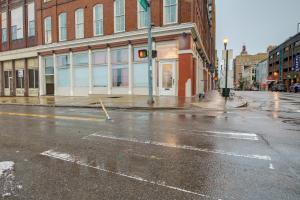 an empty city street in the rain with a building at Historic Memphis Condo Walk to Beale Street! in Memphis