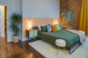 a bedroom with a bed and a brick wall at Historic Memphis Condo Walk to Beale Street! in Memphis