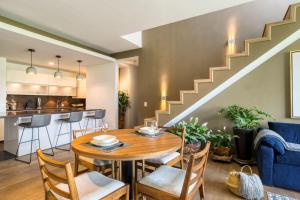 a dining room with a table and chairs and a staircase at Chic PH Haven with rooftop, Condesa 2BR By Tasman in Mexico City