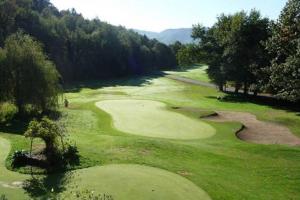 a view of a golf course with a green at Villas du Golf Domaine Royal Green in Pont-de-Larn