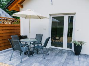 a patio with a table and chairs and an umbrella at Domek Moszna in Moszna