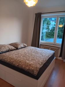 a bedroom with a bed and a large window at Spacious 70sqm apt in popular location in Düsseldorf