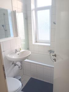 a white bathroom with a sink and a toilet at Spacious 70sqm apt in popular location in Düsseldorf