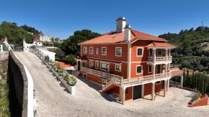 a large orange house with a balcony on a hill at High Villa in Alenquer