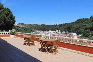 a table and chairs on a balcony with a view at High Villa in Alenquer