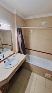 een badkamer met een wastafel en een bad bij Sofiamarholidays- Casa levante in Portimão