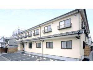 ein weißes Gebäude mit Fenstern und Balkonen darauf in der Unterkunft Business Ryokan Fukuzumi - Vacation STAY 01039v in Shizuoka