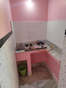 una habitación de color rosa con una radio en un estante en Sushamalay Guest House At Sea Beach, Puri, en Puri