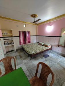 Habitación con 1 cama y 2 sillas. en Sushamalay Guest House At Sea Beach, Puri, en Puri