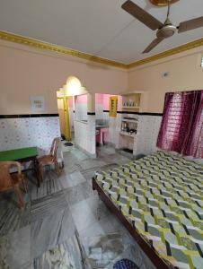 1 dormitorio con 1 cama, mesa y sillas en Sushamalay Guest House At Sea Beach, Puri, en Puri