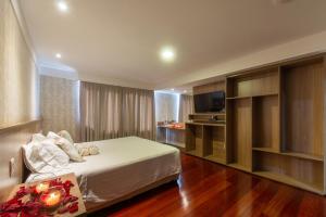 a hotel room with a bed and a television at Taiwan Hotel in Ribeirão Preto