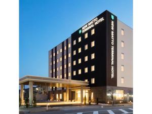 白山市にあるNew Matto Terminal Hotel - Vacation STAY 01855vの黒い建物と駐車場を持つホテル