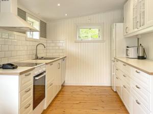 cocina con electrodomésticos blancos y suelo de madera en Holiday home UDDEVALLA XL, en Sundsandvik