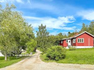 Holiday home UDDEVALLA XL في Sundsandvik: بيت احمر وبيض وطريق ترابي