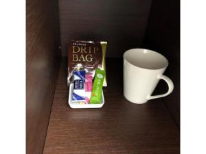 Una taza de café y una bolsa de dulces junto a una taza. en New Matto Terminal Hotel - Vacation STAY 01866v en Hakusan