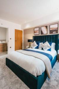 sypialnia z dużym łóżkiem z niebieskim zagłówkiem w obiekcie Pacific Suite - Wyndale Living- BHam JQ Lux 2 BR w Birmingham